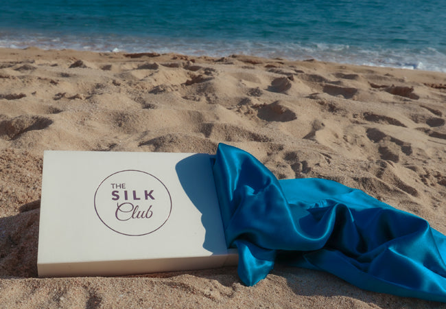 Azure Blue Silk Pillowcase in a Gift Box against a beach backdrop