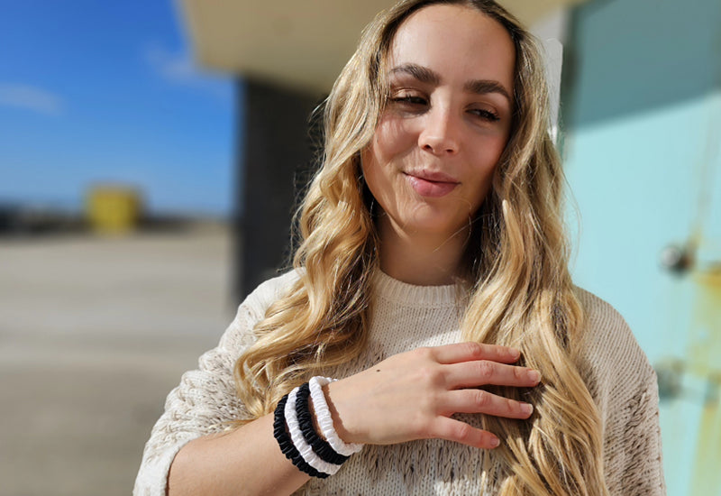 Black and white silk hair ties on model's wrist
