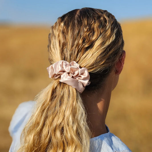 Model wearing pink silk scrunchie styled in a ponytail