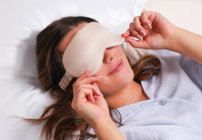 Model using an organic silk pillowcase and wearing a silk eye mask