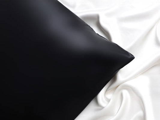 Black Silk Pillowcase Against White Silk Backdrop