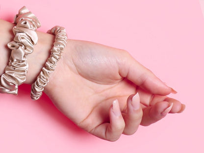 Model Wearing Dusty Pink Silk Hair Tie & Midi Silk Scrunchie On Wrist with Pink Background