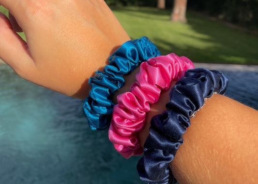 Set of 3 Midi Silk Scrunchies in Azure Blue, Navy Blue & Flamingo Pink worn on model's wrist - Silk Scrunchies