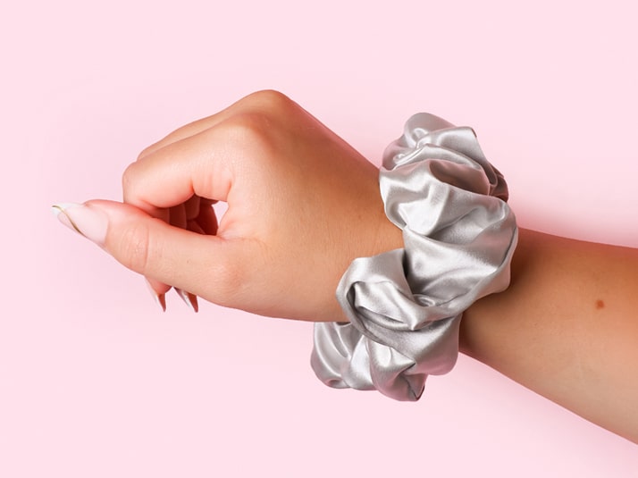 Model Wearing The Silk Club Large Silver Silk Scrunchie On Her Wrist