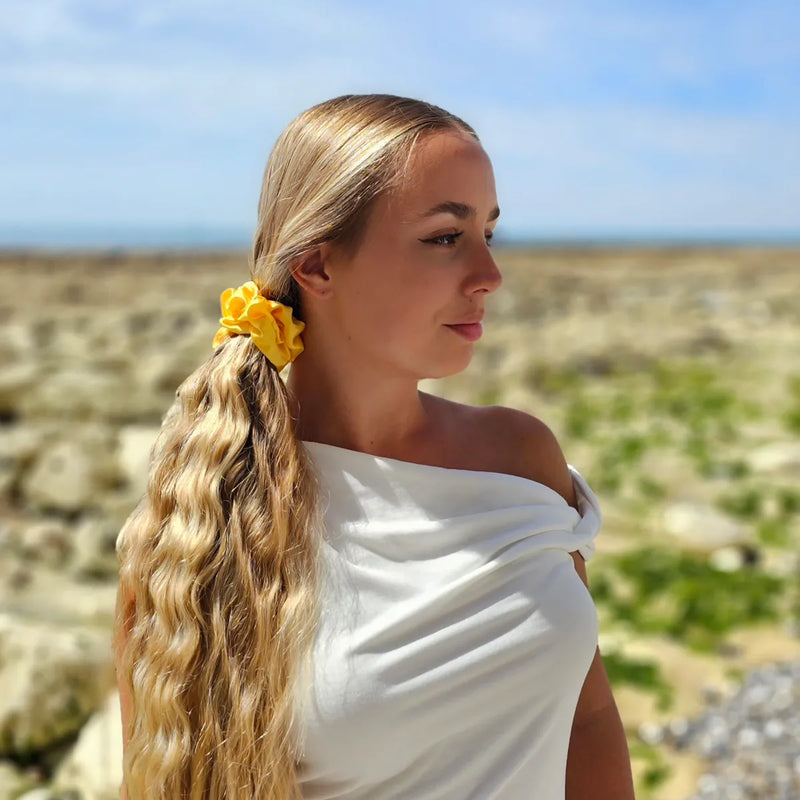 Model with long blonde hair wearing yellow scrunchie