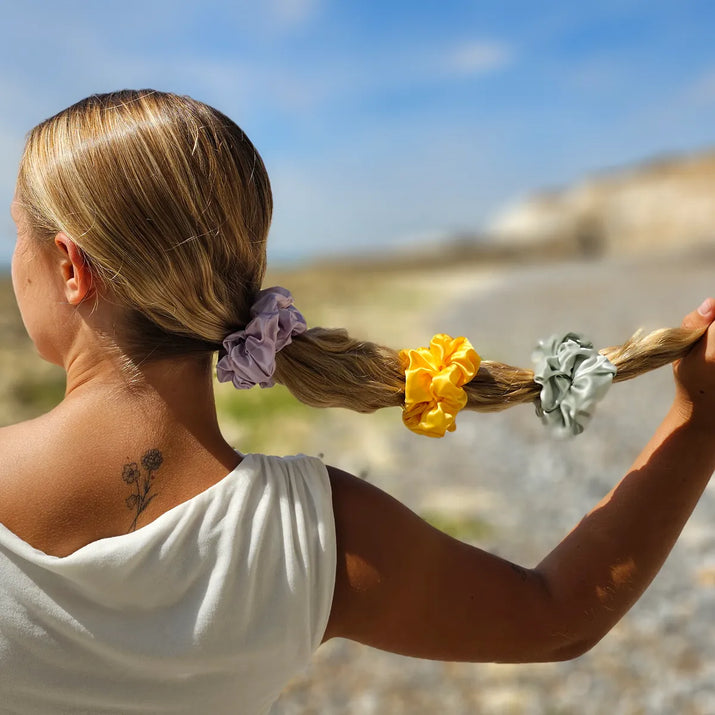 Model wearing hair styled in a bubble ponytail with lilac, yellow and mint green silk scrunchie