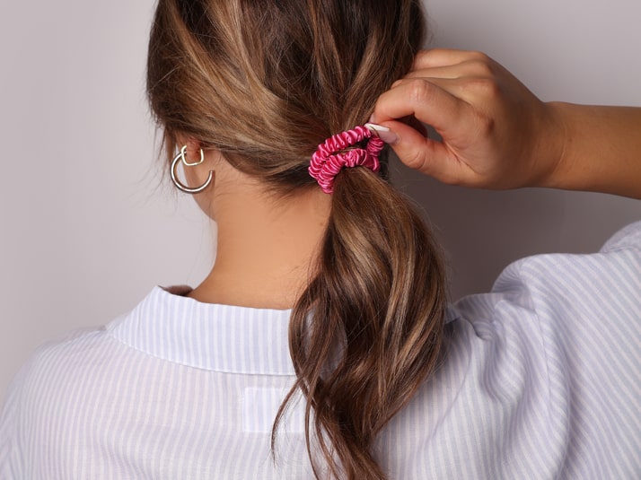 Model With Low Ponytail Tied With Flamingo Pink Silk Hair Tie