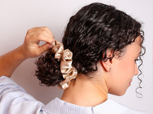 Model wearing her hair in a bun with a Champagne Large Silk Scrunchie