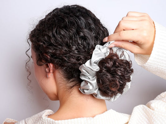 Model Wearing Hair In A Bun With The Silk Club Large Silver Silk Scrunchie