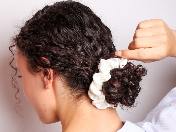 Model Wearing Low Bun Tied With A White Silk Scrunchie