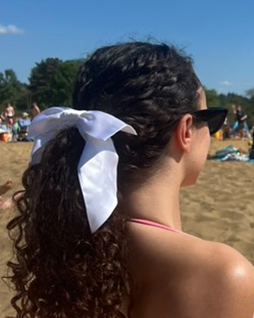 Curly Low Ponytail Styled With White Silk Hair Bow - Silk Scrunchie Hairstyle Ideas